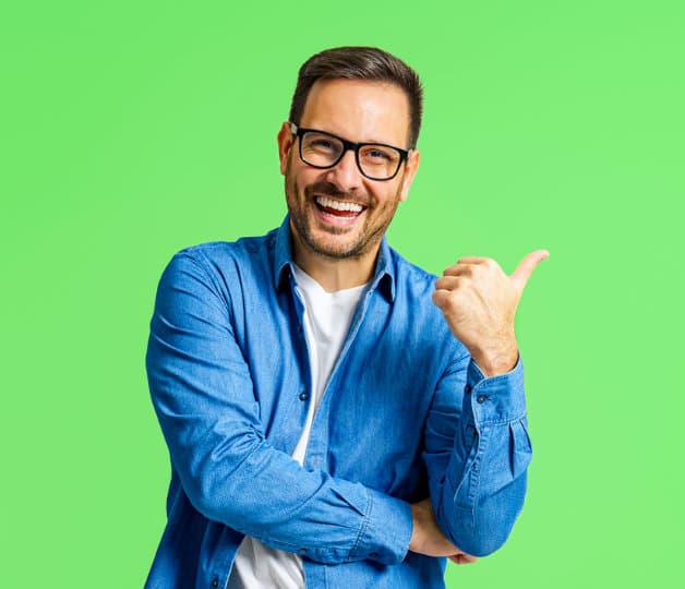 Man pointing to his left happy and looking at camera